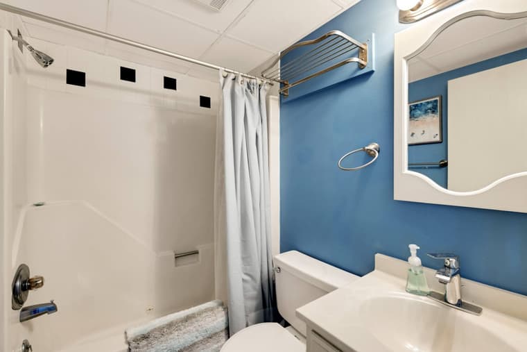 Bathroom with a tub and shower, vanity, and mirror.